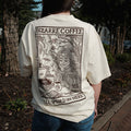 Person wearing a white t-shirt with a graphic design and text, standing outdoors.
