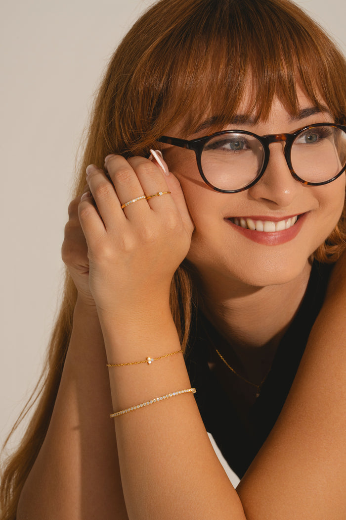 Model wearing eternity ring in gold vermeil with lab grown diamonds and other jewellery from L'ERA