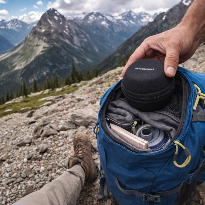 Person opening a blue backpack with a mountainous landscape in the background